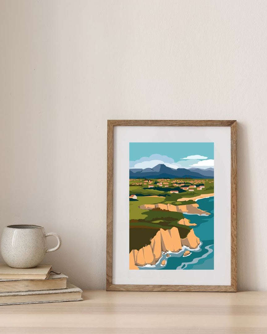 Affiche des falaises d'Abbadia à Hendaye dans un cadre en bois, en situation de décoration minimaliste.