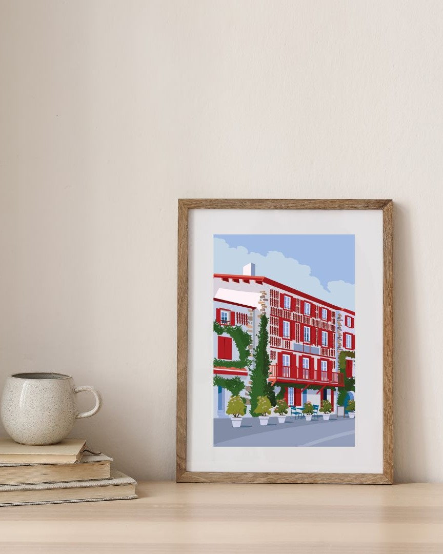 Affiche du village d'Espelette dans un cadre en bois, sur un mur épuré.