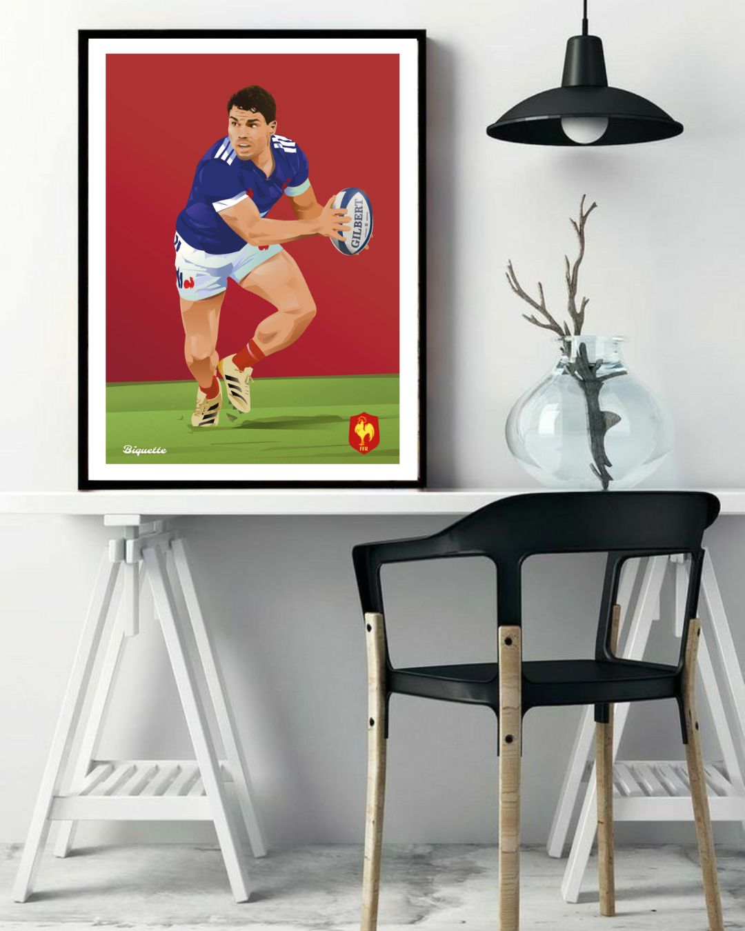 Affiche de l'Équipe de France de rugby représentant Antoine Dupont, encadrée et posée au-dessus d'une table de travail blanche avec un vase décoratif.
