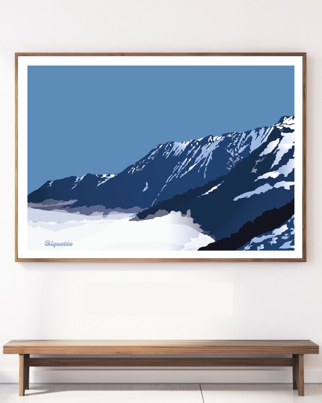 Affiche horizontale de la montagne de Piau-Engaly et sa mer de nuages, fixée au-dessus d'un banc en bois minimaliste contre un mur blanc épuré.