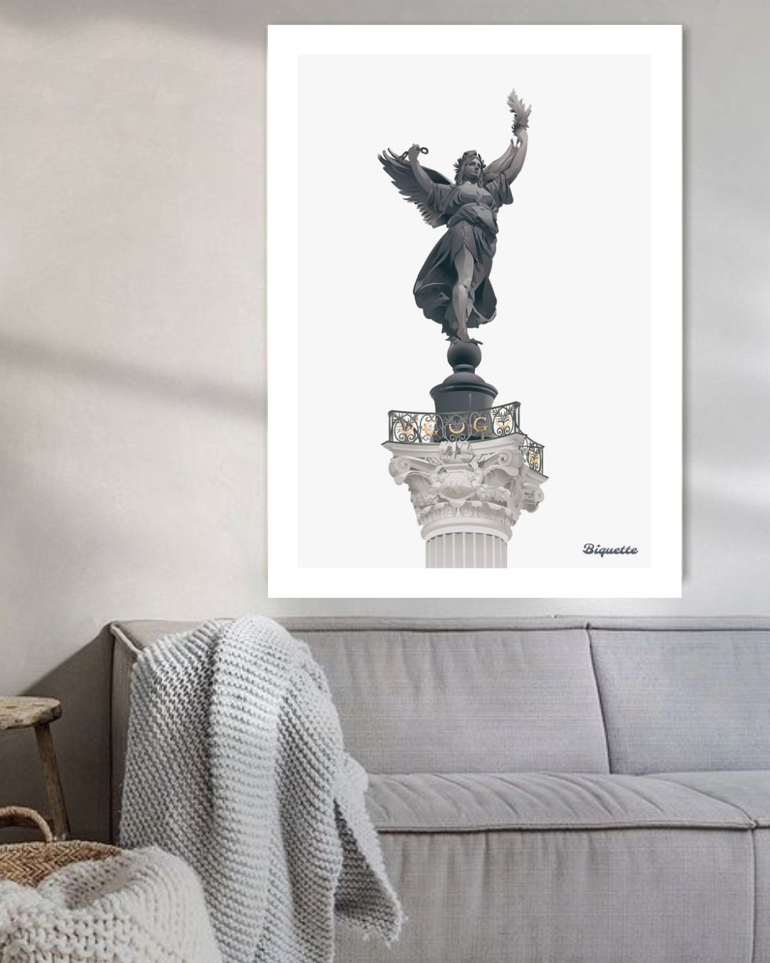 Illustration minimaliste de la colonne et de la statue du Monument aux Girondins de Bordeaux, encadrée au-dessus d'un canapé gris moderne.