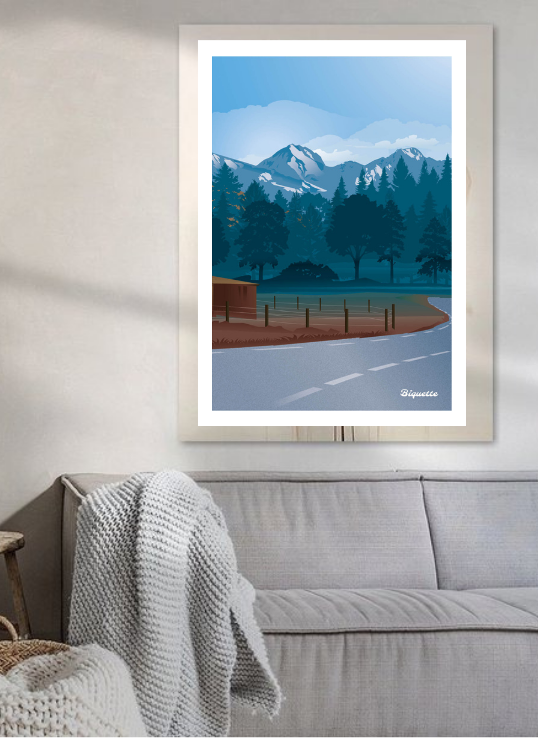 Affiche Loudenvielle encadrée dans un salon scandinave au-dessus d'un canapé gris.